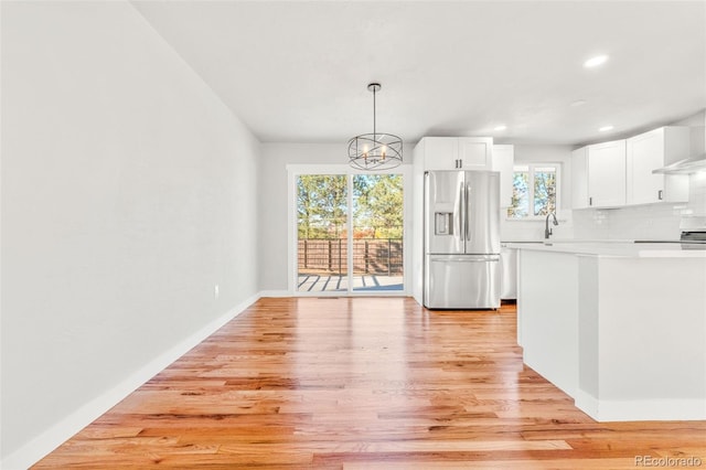 kitchen featuring light hardwood / wood-style floors, a healthy amount of sunlight, and stainless steel fridge with ice dispenser