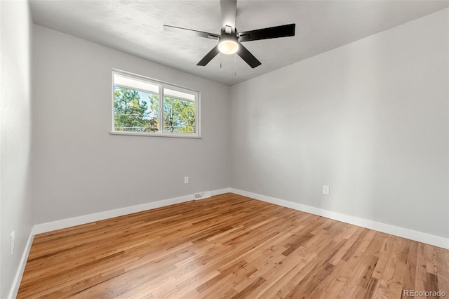 empty room with ceiling fan and light hardwood / wood-style flooring