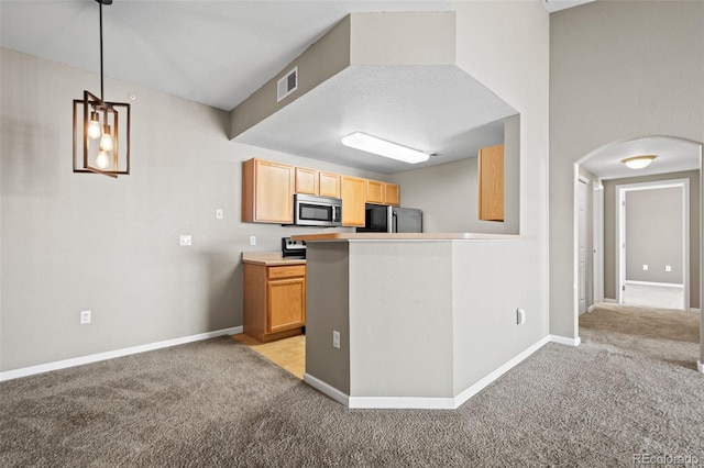 kitchen featuring light carpet, visible vents, stainless steel microwave, and freestanding refrigerator