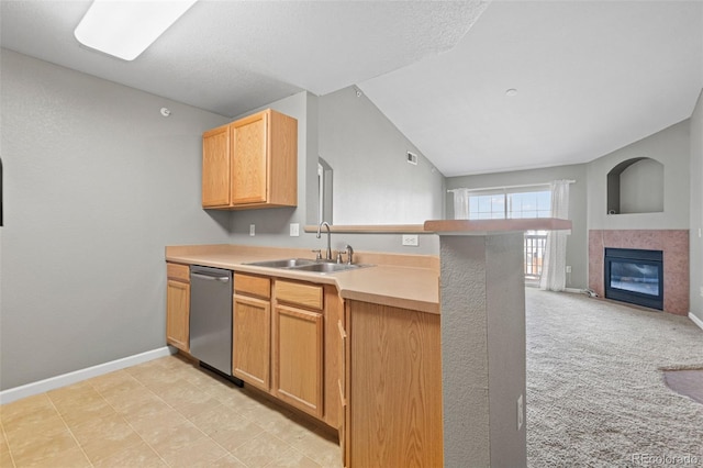 kitchen with a peninsula, a sink, vaulted ceiling, light countertops, and stainless steel dishwasher