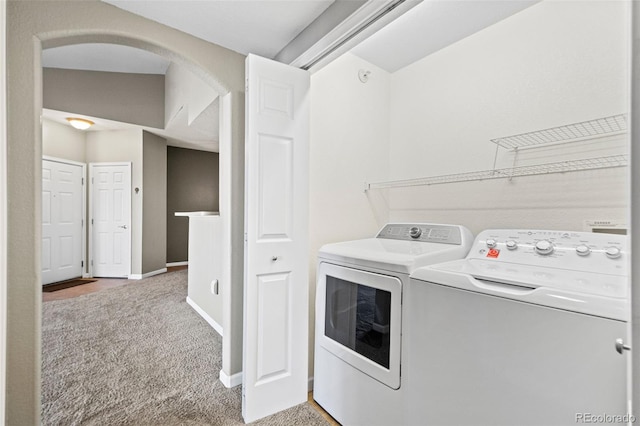 laundry area with arched walkways, carpet, washing machine and dryer, laundry area, and baseboards