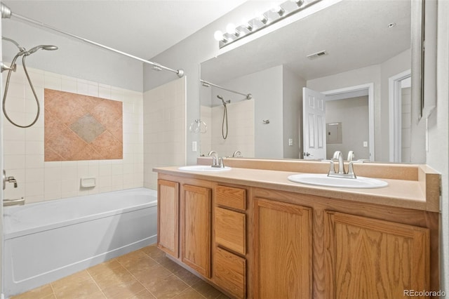 full bathroom with double vanity, washtub / shower combination, a sink, and tile patterned floors