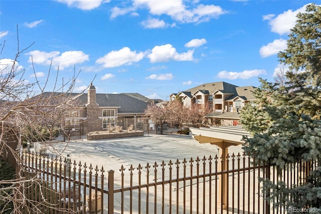 exterior space featuring a residential view, fence, and a chimney