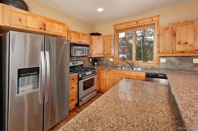 kitchen featuring tasteful backsplash, sink, light stone counters, stainless steel appliances, and light brown cabinets