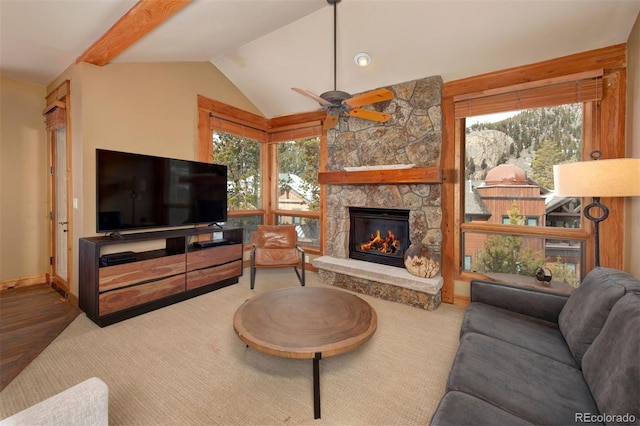 carpeted living area with a fireplace, vaulted ceiling, baseboards, and ceiling fan