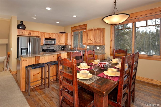 dining room featuring wood-type flooring, baseboards, and recessed lighting