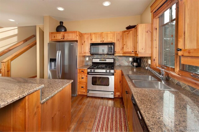 kitchen with recessed lighting, stainless steel appliances, dark wood-style flooring, a sink, and backsplash