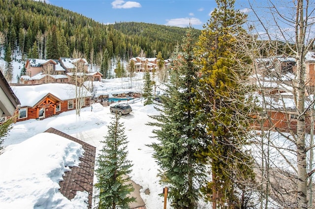 snowy aerial view with a wooded view