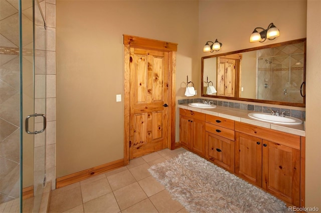 full bath featuring tile patterned flooring, a sink, and a shower stall