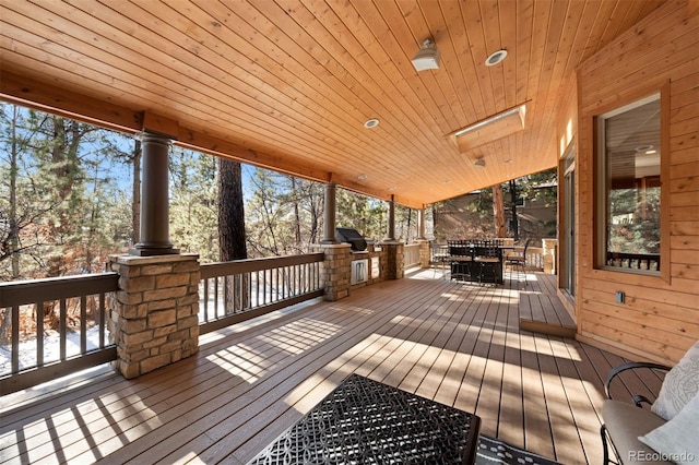 wooden terrace with grilling area and an outdoor kitchen