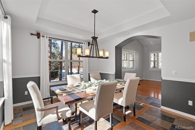 dining space featuring an inviting chandelier and a tray ceiling