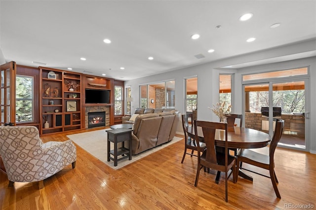 living room with a fireplace and light wood-type flooring