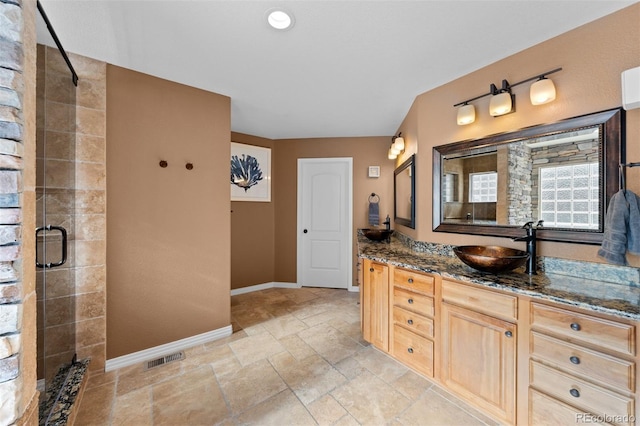 bathroom with vanity and a shower with shower door