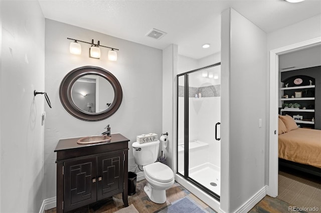 bathroom with built in shelves, vanity, toilet, and a shower with shower door