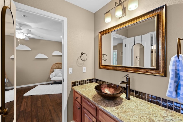 bathroom with hardwood / wood-style flooring, vanity, and ceiling fan