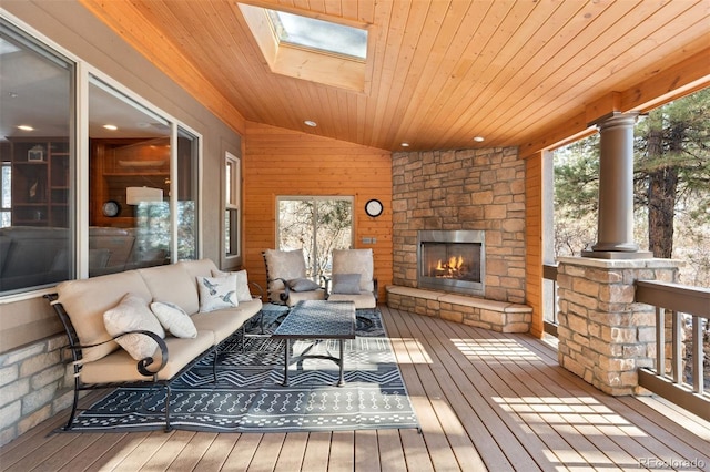 wooden terrace with an outdoor living space with a fireplace