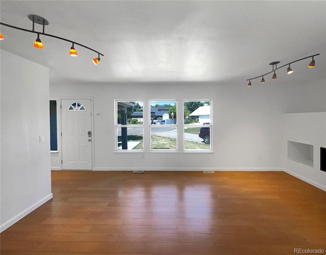 4416 S Vivian St, Morrison, CO 80465 - unfurnished living room featuring rail lighting and hardwood / wood-style flooring