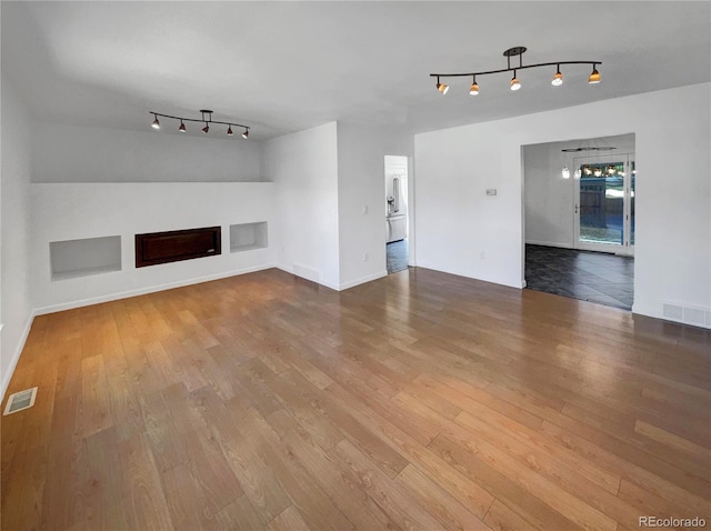 4416 S Vivian St, Morrison, CO 80465 - unfurnished living room featuring rail lighting, hardwood / wood-style flooring, and a fireplace