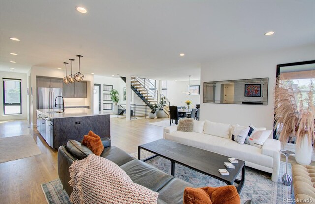 4224 E Dickenson Pl, Denver, CO 80222 - living area featuring stairway, light wood finished floors, plenty of natural light, and recessed lighting
