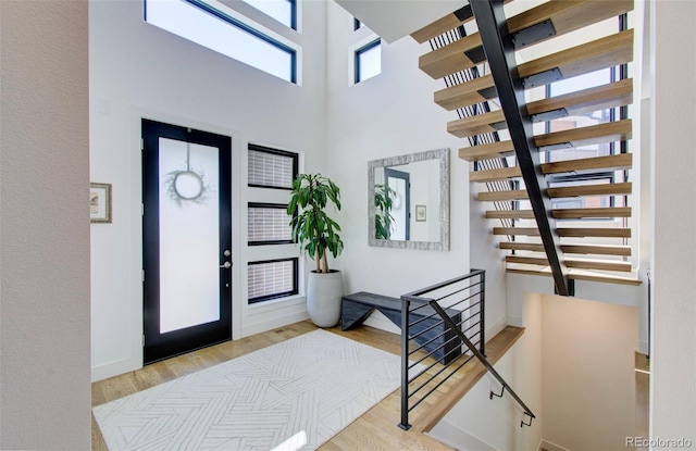 entryway with a towering ceiling and light hardwood / wood-style floors