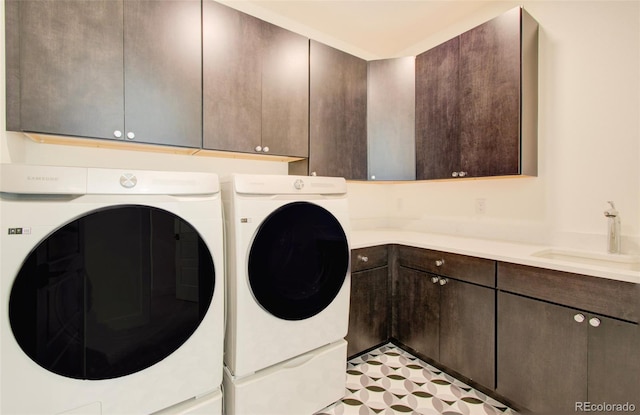 laundry room featuring cabinets, independent washer and dryer, and sink