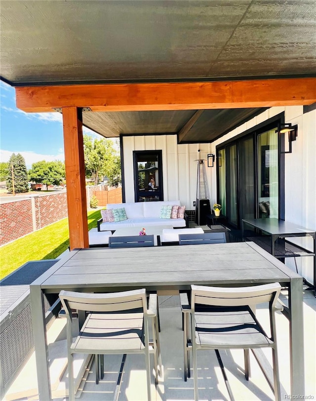view of patio featuring fence, outdoor dining area, and an outdoor living space