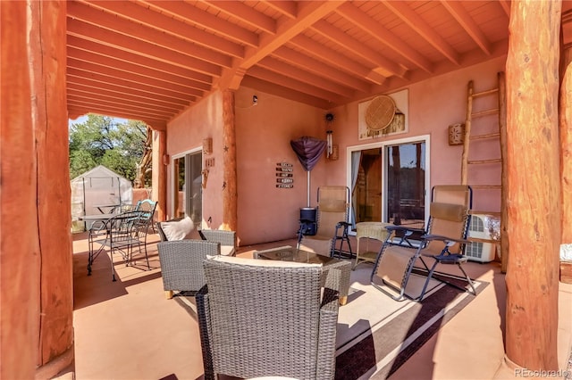 view of patio featuring an outbuilding, outdoor dining space, and a storage shed