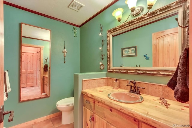 bathroom with tile patterned flooring, visible vents, crown molding, toilet, and vanity