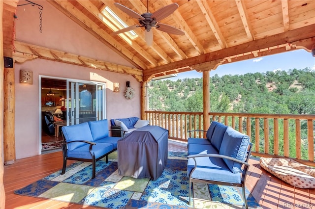 wooden terrace featuring an outdoor hangout area, a forest view, and ceiling fan