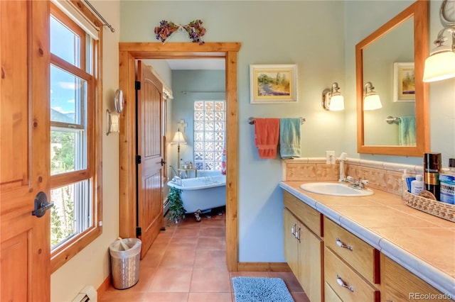 full bathroom with tile patterned floors, plenty of natural light, vanity, and a freestanding tub