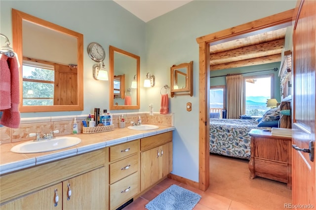 bathroom with vanity, plenty of natural light, tile patterned flooring, and beam ceiling