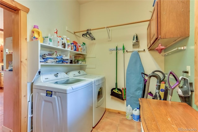 laundry room with light tile patterned floors, baseboards, cabinet space, and washing machine and dryer