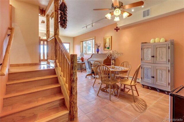 tiled dining room featuring baseboard heating and ceiling fan