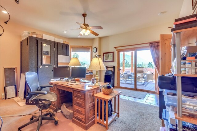 carpeted office space featuring a ceiling fan