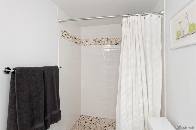 790 N Washington St Unit 1210, Denver, CO 80203 - bathroom featuring a tile shower and toilet