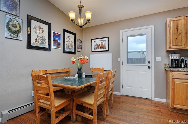 dining room with hardwood / wood-style flooring, an inviting chandelier, and a baseboard heating unit