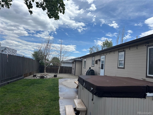 view of yard featuring a hot tub and a fire pit