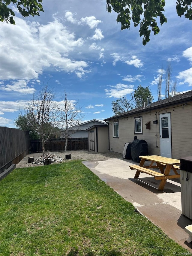 back of property featuring a storage unit, a yard, and a patio area