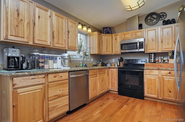 kitchen with sink, light hardwood / wood-style flooring, stainless steel appliances, light stone countertops, and light brown cabinetry