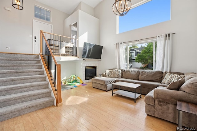 104 Willowick Cir, Highlands Ranch, CO 80129 - living area with a chandelier, a towering ceiling, stairway, wood finished floors, and a fireplace