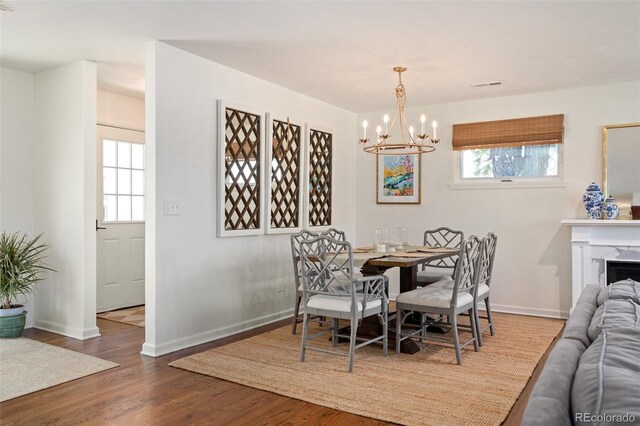 986 S Jersey St, Denver, CO 80224 - dining area with a chandelier, wood finished floors, and baseboards