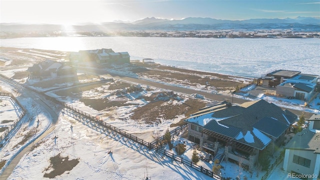 snowy aerial view with a water and mountain view