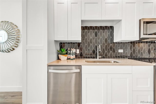 kitchen with white cabinetry, sink, decorative backsplash, and stainless steel appliances