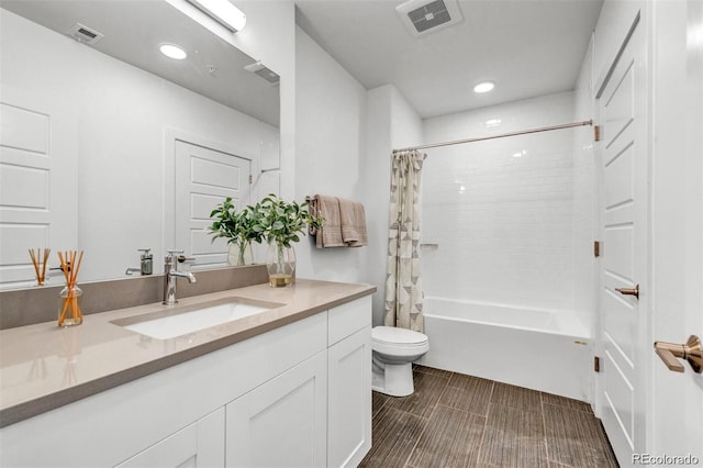 full bathroom with vanity, shower / tub combo with curtain, and toilet