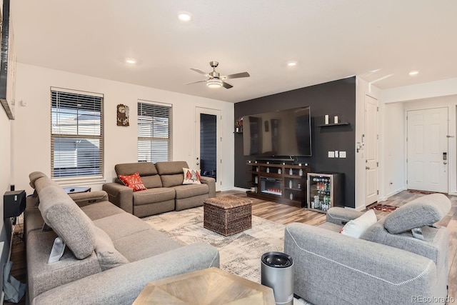 living room featuring ceiling fan, wine cooler, and light wood-type flooring