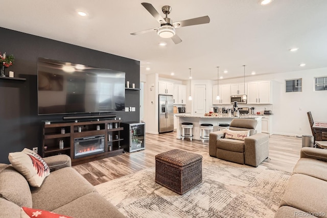 living room with ceiling fan and light hardwood / wood-style floors