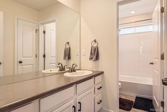 full bathroom featuring vanity, tiled shower / bath combo, and toilet