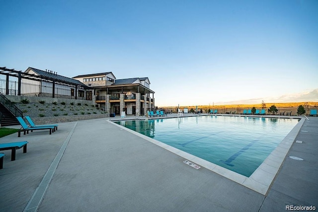 pool at dusk with a patio area