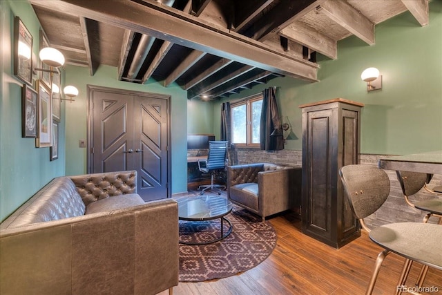 living room with beam ceiling and wood finished floors