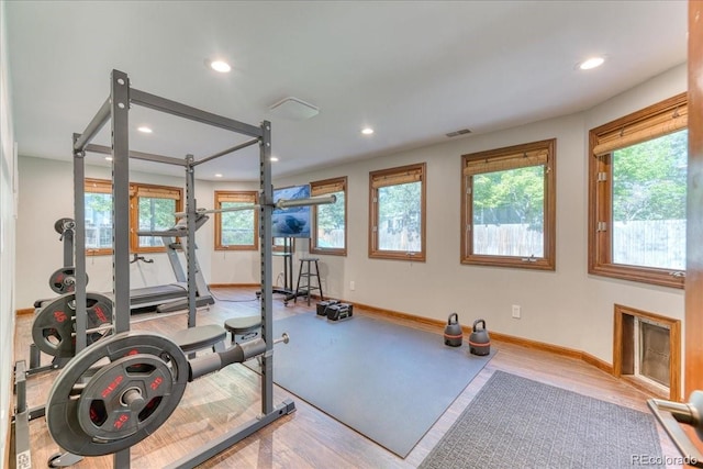 workout area with recessed lighting, healthy amount of natural light, baseboards, and wood finished floors